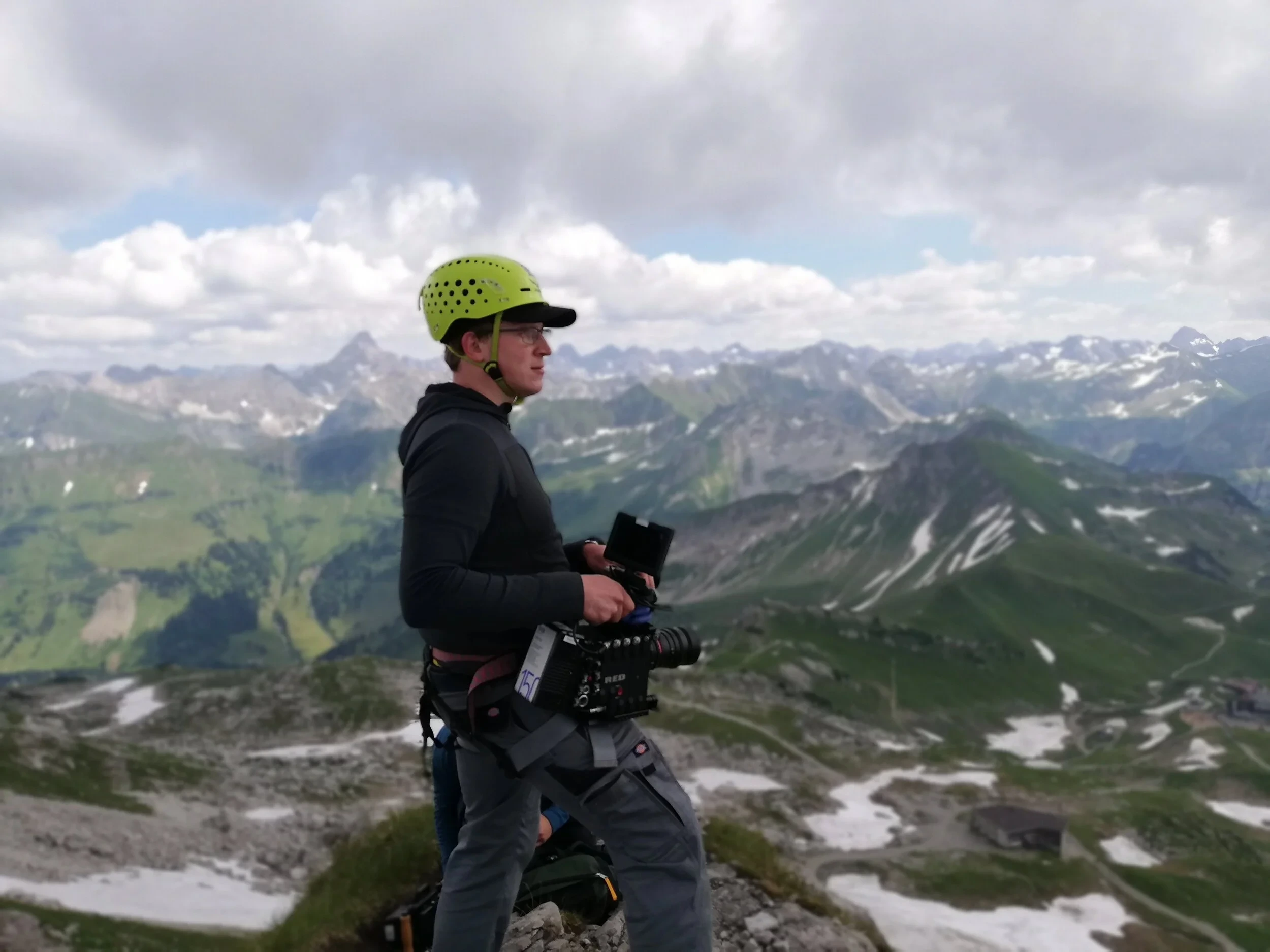Kameramann Christian Schmitz mit RED-Kamera auf Alpengipfel beim Imagefilm-Dreh
